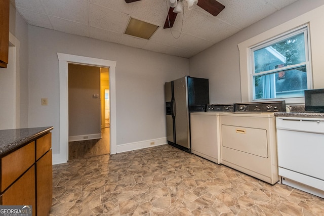 kitchen featuring ceiling fan, stainless steel refrigerator with ice dispenser, a paneled ceiling, washer and clothes dryer, and white cabinets