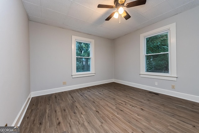 unfurnished room with dark hardwood / wood-style floors and ceiling fan