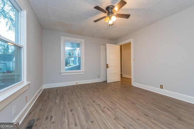 empty room with hardwood / wood-style floors and ceiling fan