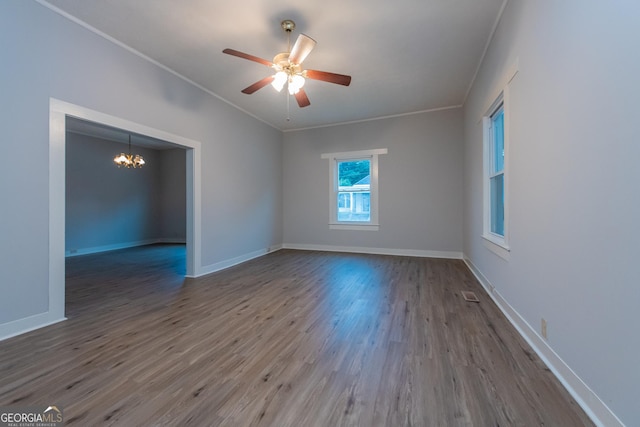 unfurnished room with hardwood / wood-style floors, ceiling fan with notable chandelier, and ornamental molding