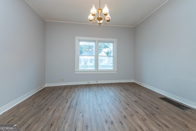 spare room with crown molding, an inviting chandelier, and hardwood / wood-style flooring