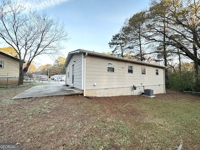 back of house with a lawn and a patio