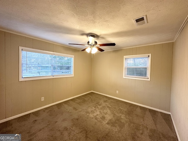 carpeted empty room with ceiling fan, ornamental molding, and a textured ceiling