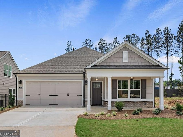 view of front facade featuring a front yard, a porch, and a garage