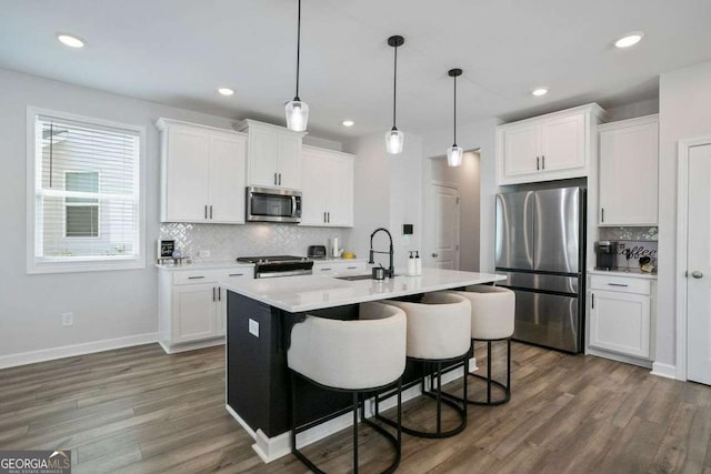 kitchen featuring white cabinetry, sink, a center island with sink, and appliances with stainless steel finishes