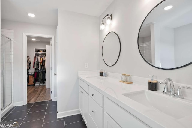 bathroom with tile patterned floors, vanity, and a shower with door