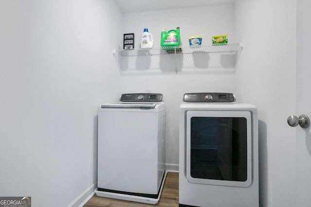 washroom with washing machine and dryer and hardwood / wood-style floors