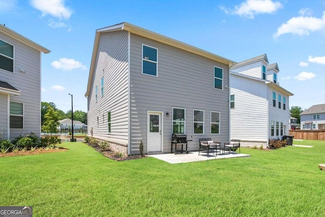 rear view of house featuring a lawn and a patio