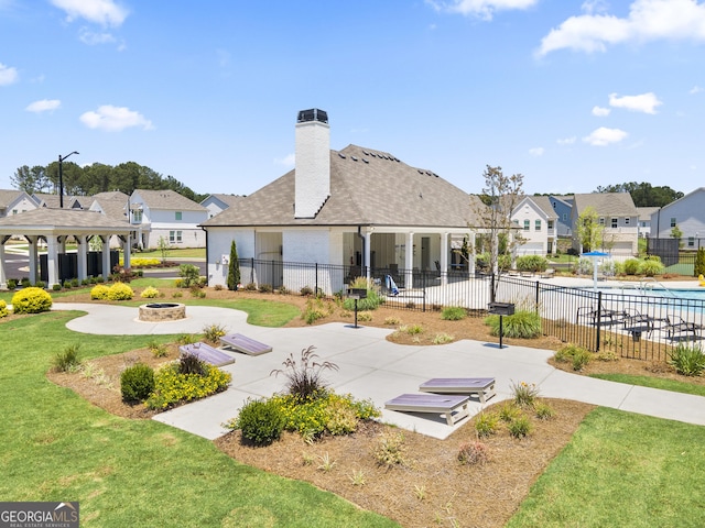 view of property's community with a lawn, a patio area, and a fire pit