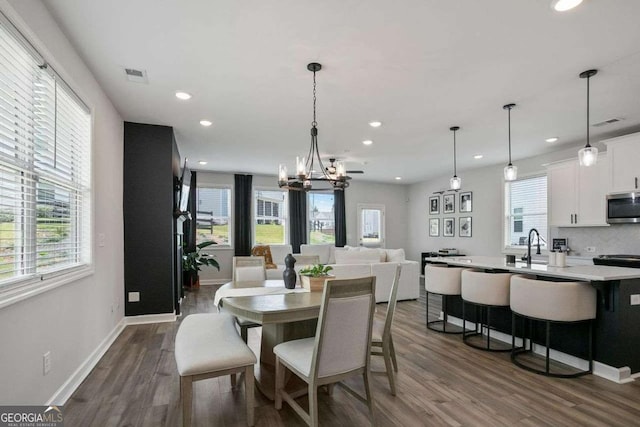 dining room featuring dark hardwood / wood-style flooring, sink, and a chandelier