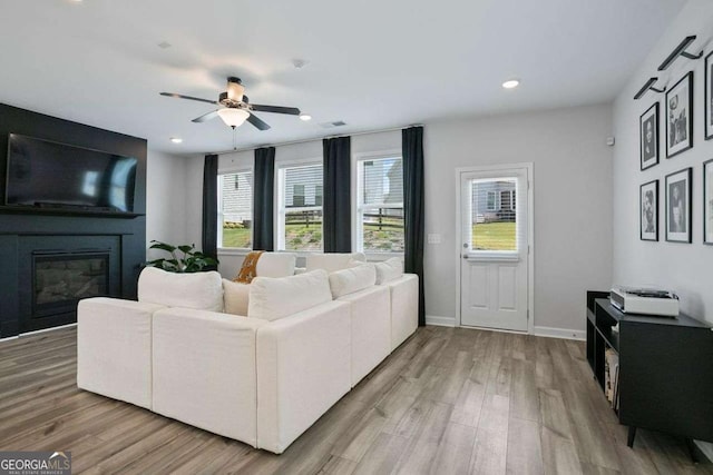 living room featuring a fireplace, hardwood / wood-style flooring, and ceiling fan