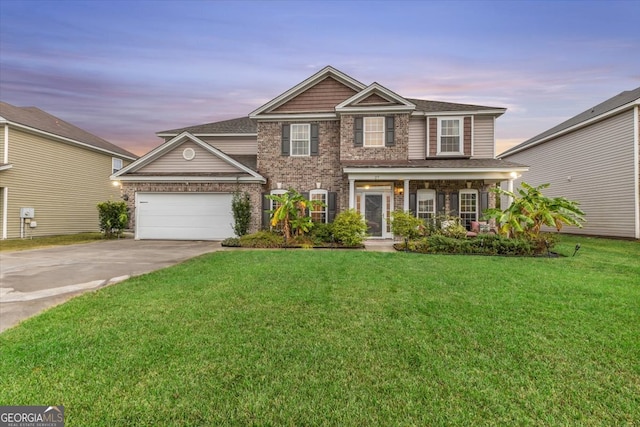 view of front of home featuring a garage and a yard