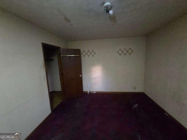 unfurnished room with a textured ceiling