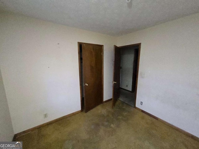 empty room featuring carpet flooring and a textured ceiling