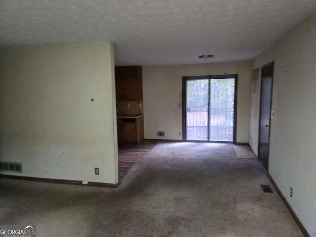 carpeted spare room with a textured ceiling