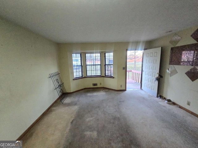 carpeted spare room featuring a textured ceiling