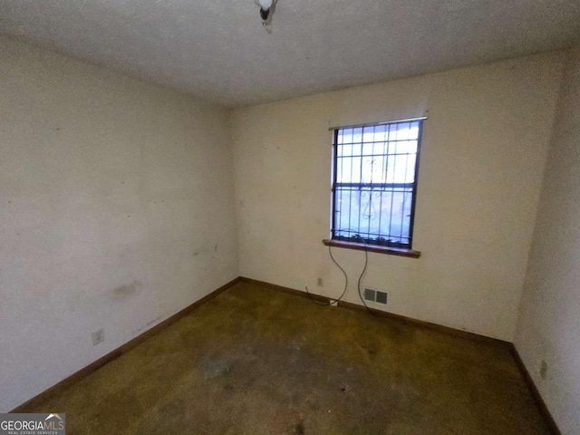 carpeted spare room featuring a textured ceiling