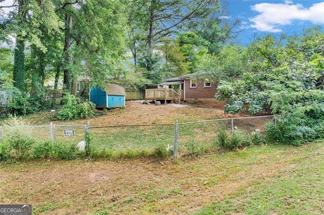 view of yard featuring a deck and a storage unit