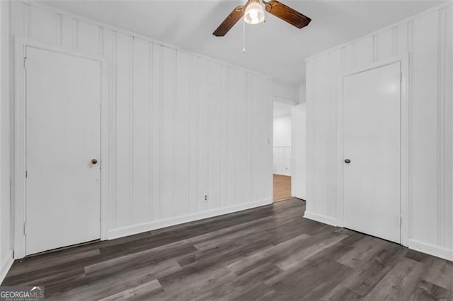 unfurnished bedroom with ceiling fan and dark wood-type flooring