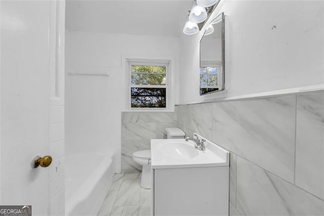 bathroom featuring vanity, tile walls, and toilet