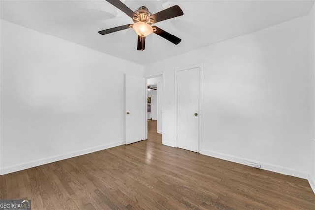 empty room featuring ceiling fan and dark wood-type flooring