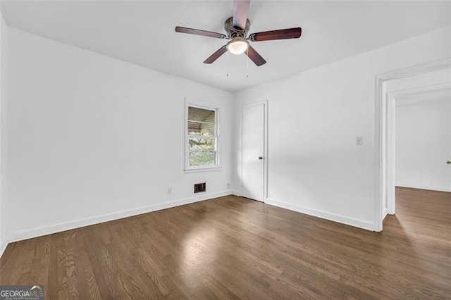 spare room featuring ceiling fan and dark hardwood / wood-style floors