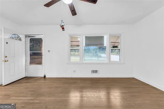 empty room featuring ceiling fan, plenty of natural light, and hardwood / wood-style flooring