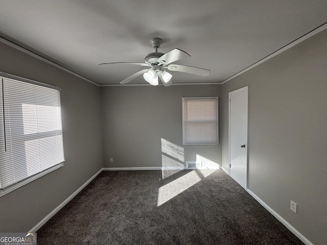 empty room featuring ceiling fan, crown molding, and dark colored carpet