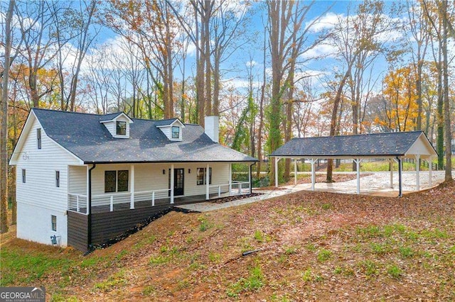 farmhouse-style home with covered porch and a carport