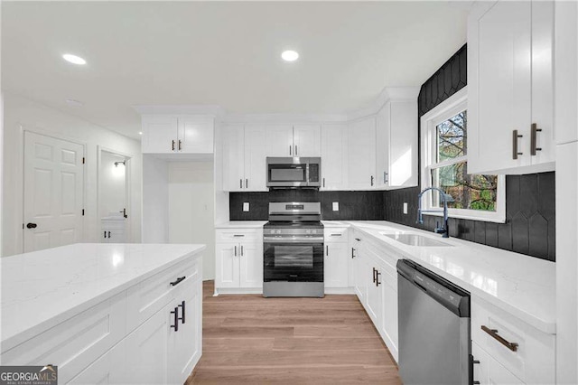 kitchen featuring white cabinets, light stone countertops, sink, and appliances with stainless steel finishes