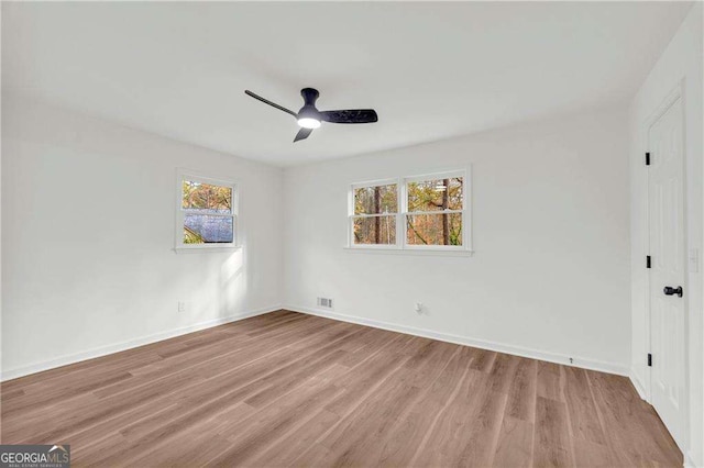 spare room with light hardwood / wood-style floors, ceiling fan, and a healthy amount of sunlight