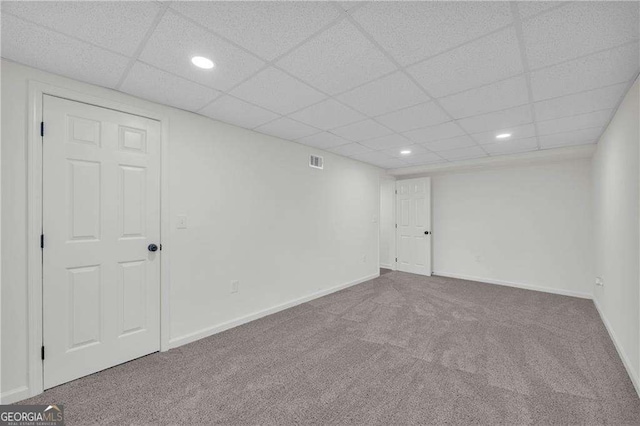 unfurnished room with a paneled ceiling and carpet floors