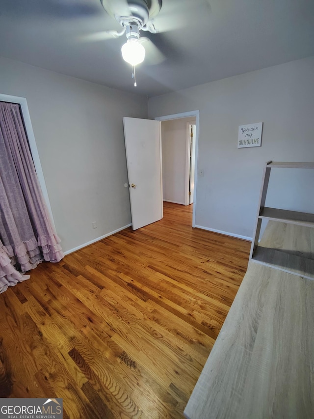 unfurnished bedroom featuring hardwood / wood-style flooring and ceiling fan