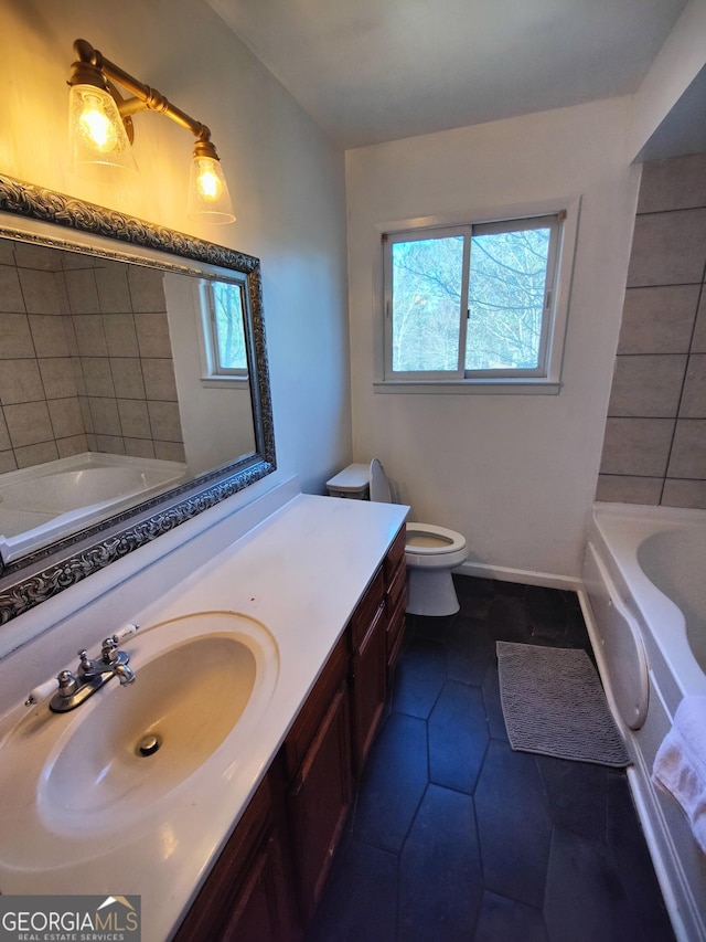 bathroom featuring tile patterned flooring, vanity, toilet, and a tub to relax in