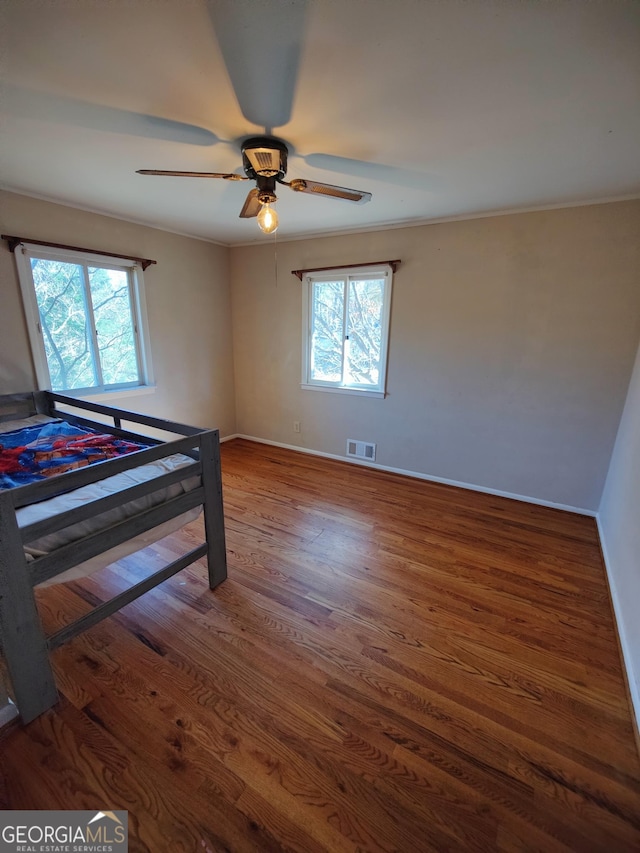 bedroom with ceiling fan and dark wood-type flooring