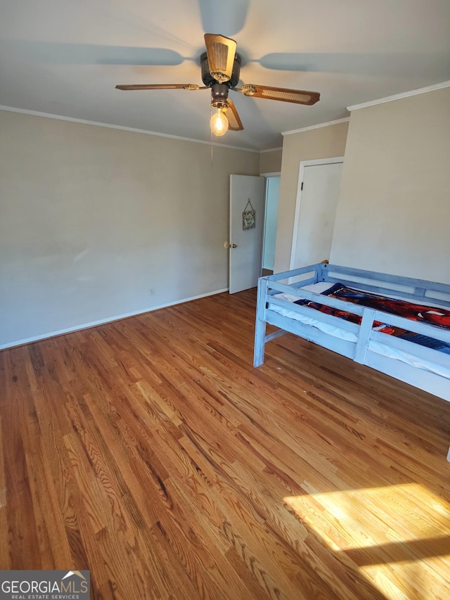 unfurnished bedroom with wood-type flooring, ceiling fan, and crown molding