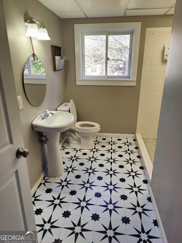 bathroom featuring sink, a drop ceiling, toilet, and walk in shower