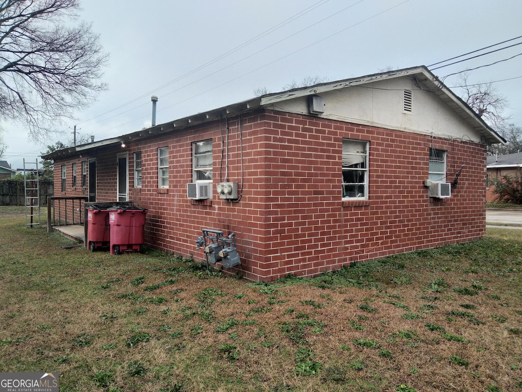 view of property exterior with cooling unit and a yard