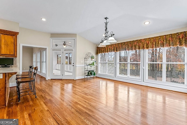 dining room featuring ceiling fan, lofted ceiling, and light wood-type flooring