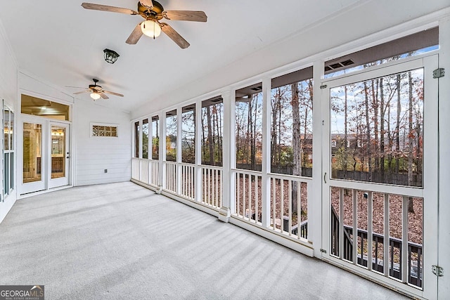 unfurnished sunroom with ceiling fan, a healthy amount of sunlight, and lofted ceiling