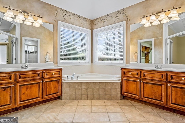 bathroom featuring tile patterned floors, vanity, and a relaxing tiled tub