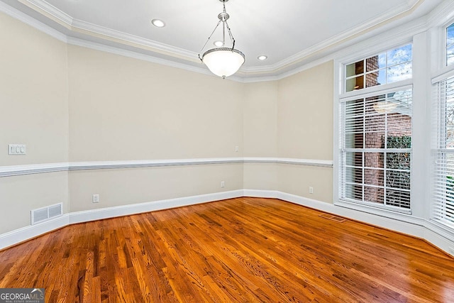 spare room with hardwood / wood-style floors, plenty of natural light, and ornamental molding