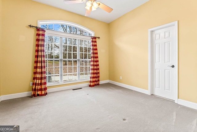 empty room featuring ceiling fan and carpet