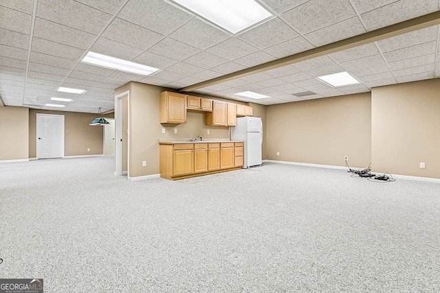 basement with light carpet, a drop ceiling, and white refrigerator