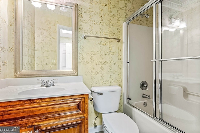 full bathroom featuring vanity, enclosed tub / shower combo, and toilet