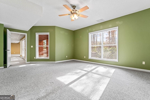 carpeted spare room featuring ceiling fan and a textured ceiling