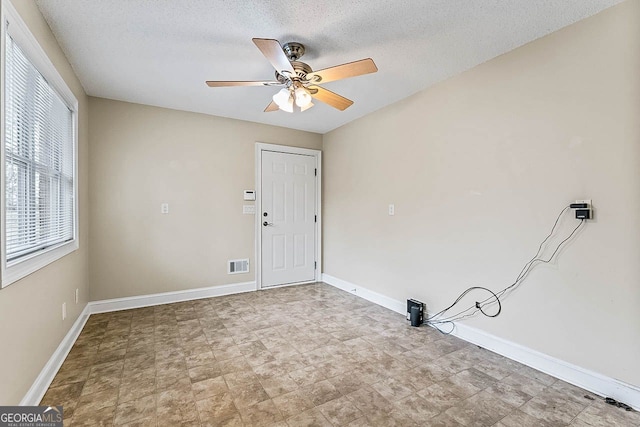 spare room featuring a textured ceiling and ceiling fan