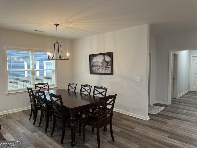 dining area featuring dark hardwood / wood-style flooring and an inviting chandelier