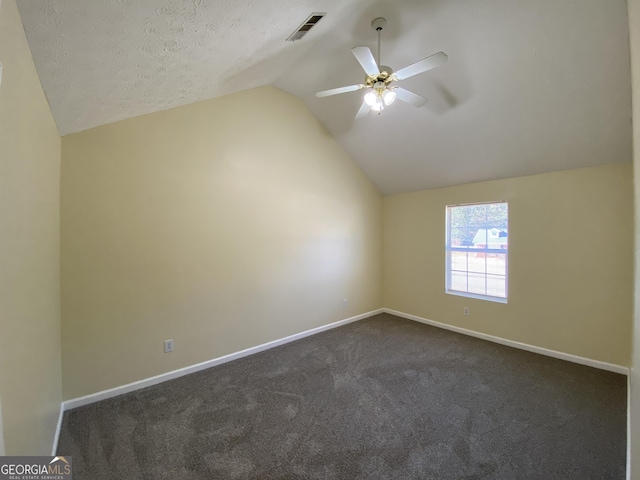 additional living space featuring a textured ceiling, ceiling fan, dark carpet, and lofted ceiling