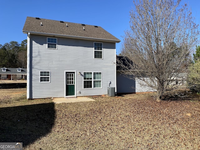 back of house featuring central AC and a yard